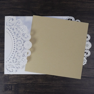 Macro detail of laser-cut floral wedding invitation with brown kraft paper insert