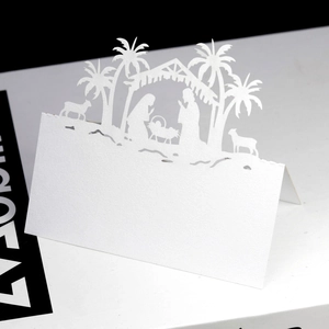 Detail of white laser-cut Nativity place card showing intricate silhouette on pearl paper