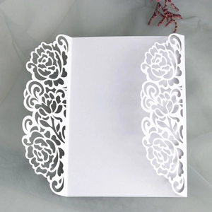 Elegant white laser-cut rose hollow wedding invitation cover on soft tulle background