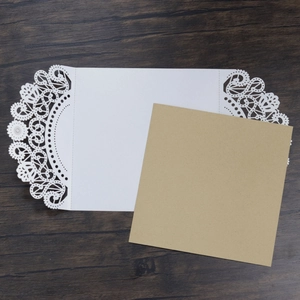 Macro detail of laser-cut wedding invitation showing delicate pattern and kraft paper liner