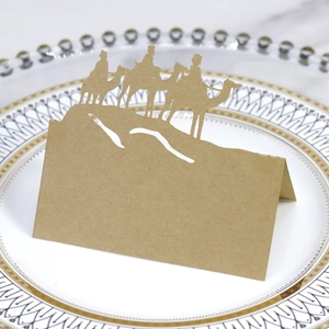 Close-up of laser-cut kraft paper place card with camel desert silhouette on a plate