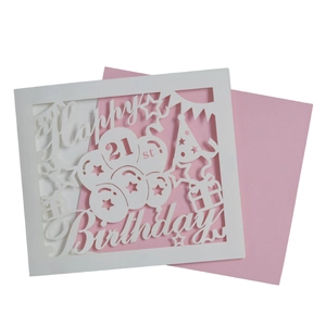 Detailed laser cut white 21st birthday card with pink envelope and party elements