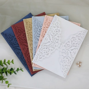 Detail of laser-cut wedding invitations showing six colors and elegant lace patterns