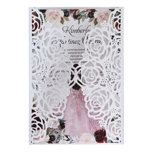 Détail des motifs de roses découpés au laser sur une invitation de mariage blanche élégante