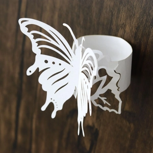 Macro shot of laser-cut butterfly napkin ring with intricate hollow patterns for weddings