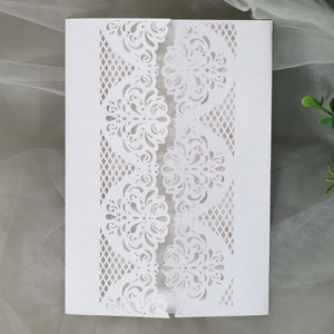 Elegant white laser-cut wedding invitation with intricate floral hollow-out patterns