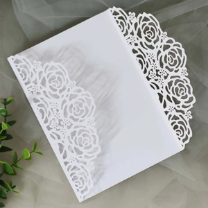 Détails de motifs de roses découpés au laser sur une élégante couverture d'invitation blanche