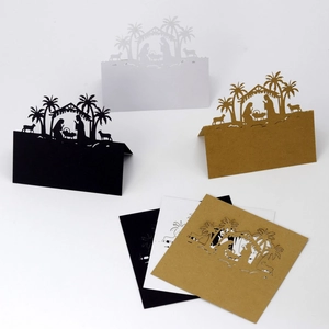 Detailed laser-cut nativity scene on black, white, and kraft paper table cards