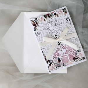 Detailed laser-cut wedding invitation with rose insert card, envelope and white ribbon bow