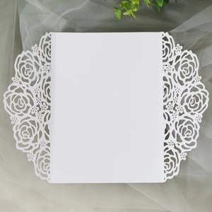 Détail de l'invitation de mariage blanche découpée au laser avec motif de rose