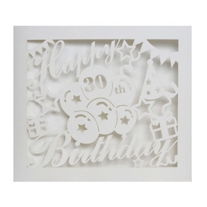 Macro shot of laser-cut white Happy 30th Birthday card with balloon and star details
