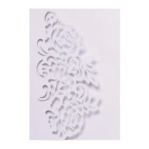 Macro detail of laser-cut rose patterns on elegant white wedding invitation card