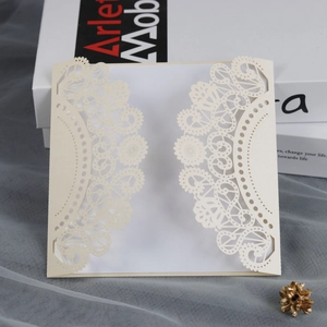 Detailed laser-cut lace design on a beige pearl paper wedding invitation card