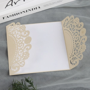 Detail of laser-cut floral pattern beige invitation cover with white inner sheet