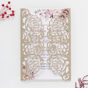 Close-up of laser-cut rose hollow invitation with gold glitter and floral inner sheet