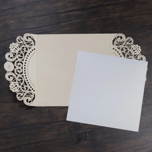 Detail of laser-cut lace pattern on cream wedding invitation with square insert