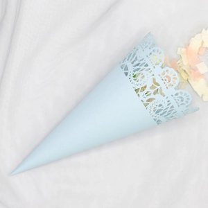 Close-up of light blue lace paper cone with delicate laser-cut edges and confetti