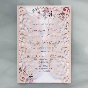 Detail of laser-cut rose hollow invitation with elegant floral insert on soft tulle