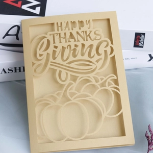 Detailed laser-cut Happy Thanksgiving card featuring a hollow pumpkin design on beige paper