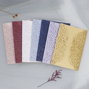 Macro detail of laser-cut rose patterns on elegant pearlescent wedding invitation covers