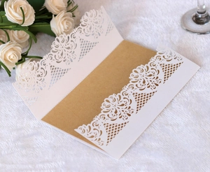 Macro detail of laser-cut floral patterns on elegant white wedding invitation sleeve
