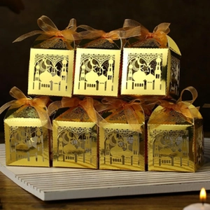 Goldene lasergeschnittene Eid-Geschenkboxen mit Moscheemustern und orangefarbenen Bändern