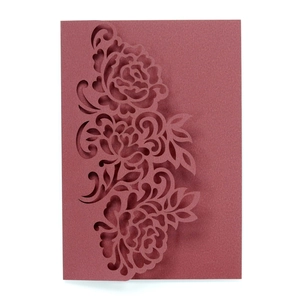 Elegant laser-cut burgundy invitation card with intricate floral patterns on white background