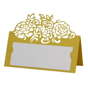 Close-up of laser-cut rose hollow place card in gold pearlescent paper with white insert