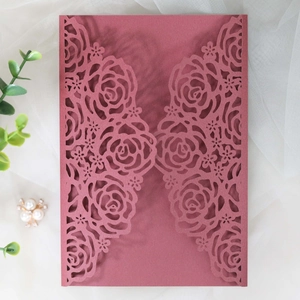 Détails de motifs de roses découpés au laser sur couverture d'invitation de mariage bordeaux