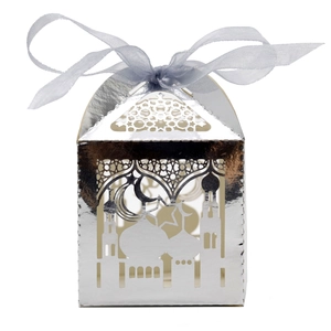 Macro shot of silver laser-cut gift box with mosque motifs and a purple ribbon bow
