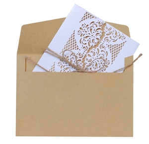 Macro detail of laser-cut floral invitation with kraft envelope and natural twine