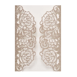 Macro shot of laser-cut floral patterns on golden glitter champagne invitation cover