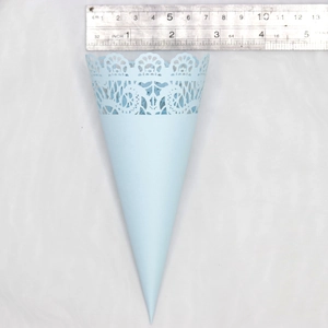 Detail of light blue lace paper cone showing intricate hollow carving and size measurements