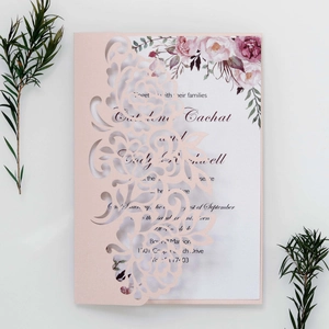 Detail of laser cut flower pattern on a pink invitation card with watercolor floral inner