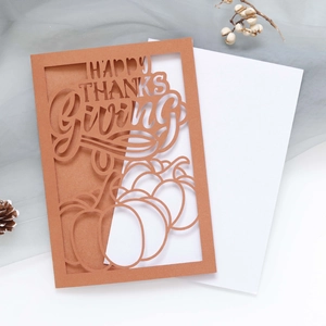 Detail of laser-cut Happy Thanksgiving card with pumpkin motifs on brown kraft paper