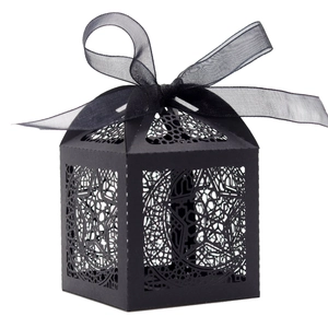 Detail of laser-cut black gift box with star and moon patterns and a black silk ribbon