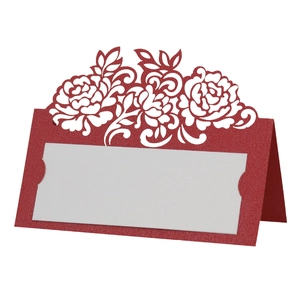Macro view of burgundy laser-cut floral wedding place card with a white insert