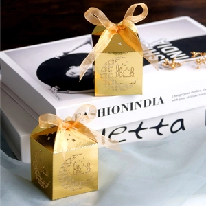 Detail of gold hollow laser-cut gift boxes with ribbons for moon and mosque festive party