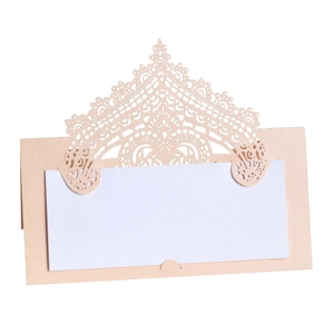 Macro detail of laser-cut lace pattern on pink pearlescent paper wedding place card