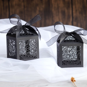 Elegant black laser-cut gift boxes with moon and star patterns and satin ribbons