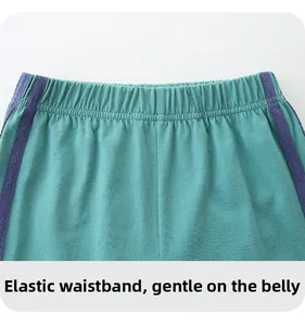 Detail of mint green boys' shorts with elastic waistband and purple side stripes