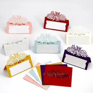 Detailed laser-cut hollow rose pattern on pearlescent paper wedding place cards