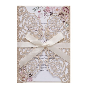 Detail of glitter gold laser cut rose invitation with cream ribbon and floral inner card