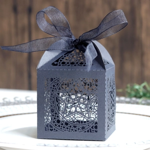 Macro detail of laser-cut moon and star patterns on silver cardstock gift box