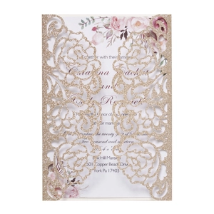 Detailed laser-cut rose patterns on a gold glitter wedding invitation card set