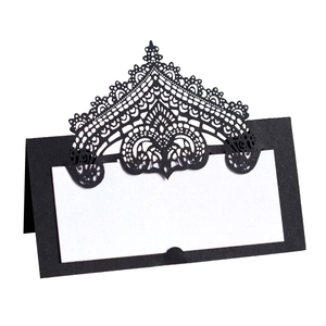 Detail of laser-cut black lace place card with intricate baroque pattern and white insert