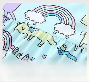 Detail of the elastic gathered waist and unicorn rainbow print on girls' light blue dress