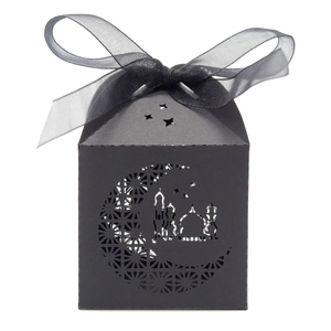 Close-up of black laser-cut candy box with hollow moon and mosque pattern and silk ribbon