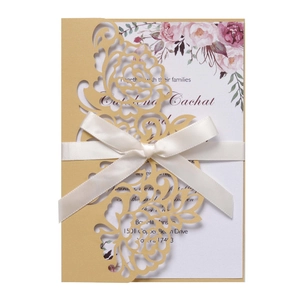 Elegant laser-cut champagne gold wedding invitation with floral insert and white satin bow
