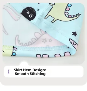 Detail of baby dress hemline showing flat stitching and cute cartoon dinosaur patterns